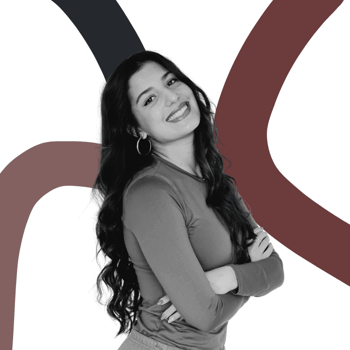 Smiling woman with crossed arms in front of abstract colored background.